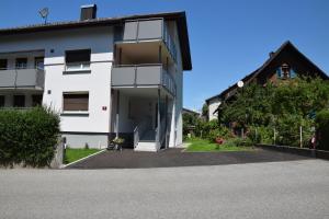 a white apartment building with a driveway at Schottar FeWo MG 07 in Dornbirn