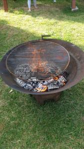 a grill that is sitting on the grass at Pensiunea Bun'88 in Corbeni