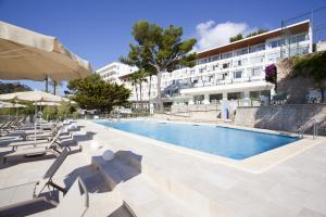 a swimming pool in front of a building at Grupotel Molins in Cala de Sant Vicent