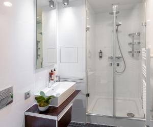 a white bathroom with a sink and a shower at VN3 Terraces Suites by Adrez in Prague