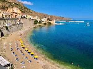 a beach with chairs and umbrellas in the water at Casa Vacanza nel cuore di Castellammare del golfo in Castellammare del Golfo