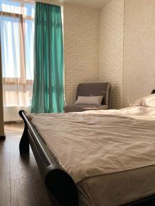 una camera da letto con un letto e una sedia accanto a una finestra di Апартаменты возле моря a Odessa