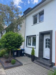 una casa blanca con un árbol delante en Casa Arturo Düsseldorf, en Düsseldorf