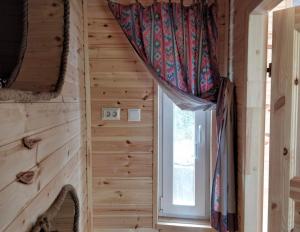 a window in a wooden room with a curtain at Roosa maja parvesaunaga in Reigi