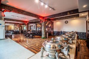 a row of pots in a room with tables and chairs at Snow Bloom Resort in Manāli