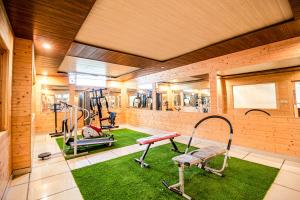 a gym with treadmills and machines in a room at Snow Bloom Resort in Manāli