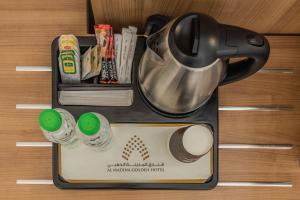 a black tea pot and utensils on a table at Al Madina Golden Hotel in Al Madinah