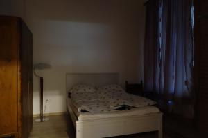 an unmade bed in a bedroom next to a window at RingAvenue Apartments Budapest in Budapest
