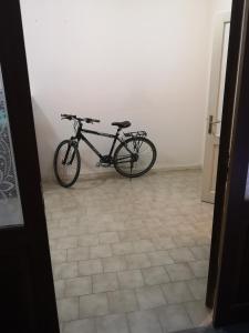 una bicicletta parcheggiata in una stanza con pavimento piastrellato di Bike Civico 17 AFFITTA CAMERE a Venzone