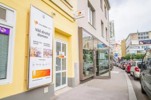 a yellow building with a sign on the side of a street at Internesto Brno in Brno