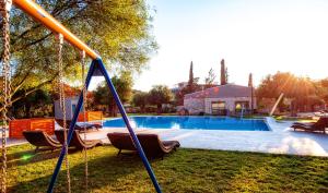 a swing in a yard with a swimming pool at LAGUNA HOLIDAY RESORT in Corfu Town