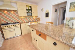 a kitchen with white cabinets and a counter top at Westfield House - Characterful 7 bedroom townhouse in Skipton