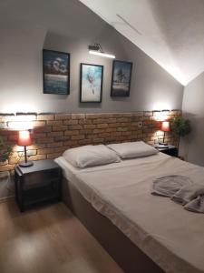1 dormitorio con 1 cama, 2 lámparas y pared de ladrillo en Akdeniz apart hotel en Marmaris