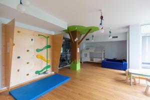 ワルシャワにあるEspace Wilanów Apartments by Noclegi Rentersのロッククライミングウォールと木のある部屋