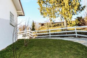 a white fence next to a yard with grass at Oh-Apartment Lindenberg in Lindenberg im Allgäu