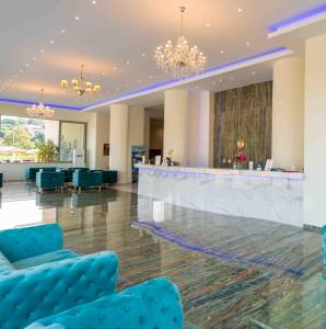 a lobby with blue chairs and a bar at LAGUNA HOLIDAY RESORT in Corfu Town