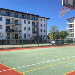 a basketball court in front of a building at Apartament Tsuru in Dziwnówek +15 photos