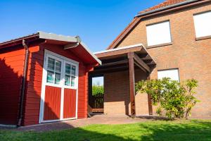 une maison en briques rouges avec une porte rouge dans l'établissement Ferienhaus Kristina, à Hooksiel