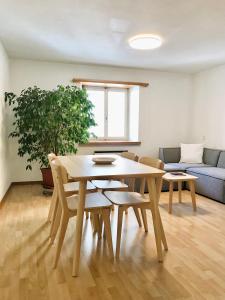 uma sala de estar com uma mesa de madeira e cadeiras em Centrally Located Apartment in Poschiavo em Poschiavo
