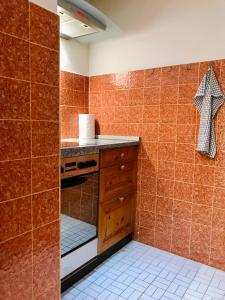 a kitchen with orange tiled walls and a stove at Centrally Located Apartment in Poschiavo in Poschiavo