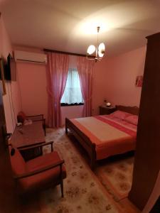1 dormitorio con 1 cama, 1 silla y 1 ventana en Apartman Jaredić - Private Accommodation, Privatni Smeštaj, en Donji Milanovac