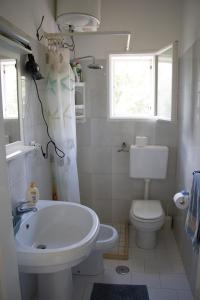 a white bathroom with a sink and a toilet at Ostuni home nature in Ostuni