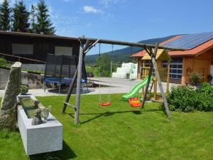 un parque infantil en un patio con un columpio en Schusterbauer - Chiemgau Karte, en Inzell