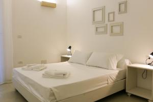Una cama blanca con sábanas blancas y toallas. en Trullo TerraNostra villa con piscina Torre San Giovanni, en Ugento