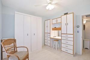 - une chambre avec des placards blancs, une chaise et un bureau dans l'établissement Relaxing condo with two pools and steps to beach, à Marco Island 23 autres photos
