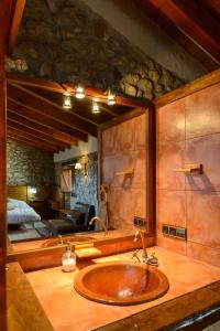 een badkamer met een houten wastafel in een kamer bij Suite deluxe en casa rural in Bas