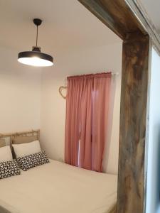 a bedroom with a bed and a pink curtain at הצימר של יהושע in Ein Gedi