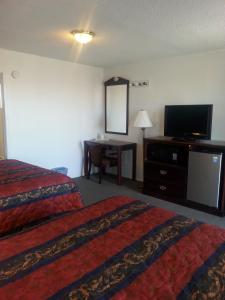 Una habitación de hotel con dos camas y un televisor de pantalla plana. en Budget Inn, en Fort Stockton