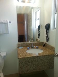Un baño con lavabo y un espejo grande. en Budget Inn, en Fort Stockton 13 fotos más