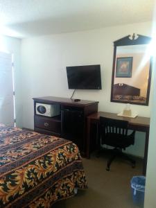 Una habitación de hotel con una cama y un escritorio con una computadora. en Budget Inn, en Fort Stockton