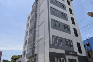Classio Residency في بونديتْشيري: مبنى أبيض طويل عليه علامة