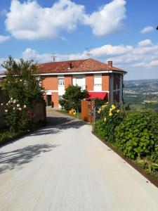 uma estrada que leva a uma casa vermelha com flores em Apartment AL34 em La Morra