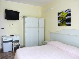ペスカーラにあるLe Mimoseのベッドルーム1室(ベッド1台、壁掛けテレビ付)