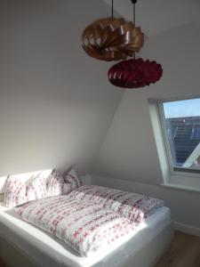 1 dormitorio con cama con almohadas y ventana en Haus Svenja en Westerland