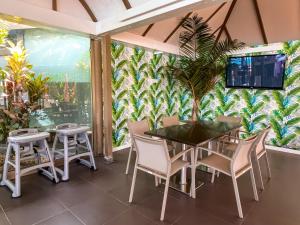 
a patio area with a table, chairs, and umbrellas at Bungalows Cordial Sandy Golf in Maspalomas
