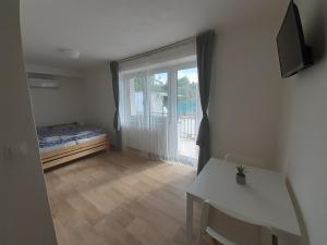 a room with a bed and a table and a window at Valen apartmány Valtice in Valtice