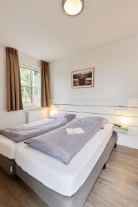 a bedroom with two beds and a window at UplandParcs Residence Astenberg in Winterberg