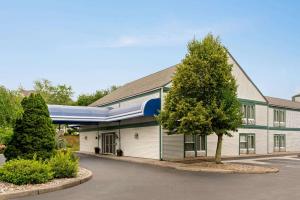 a building with a tree in front of it at Baymont by Wyndham North Dartmouth Fall River in North Dartmouth