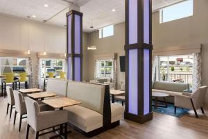 a dining room with tables and chairs and windows at Days Inn & Suites by Wyndham Bowling Green in Bowling Green