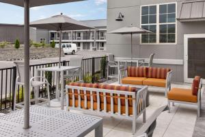 a patio with chairs and tables and umbrellas at Days Inn & Suites by Wyndham Bowling Green in Bowling Green