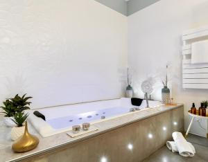 eine Badewanne im Bad mit weißen Wänden in der Unterkunft Host inn Lyon - Appartement de Luxe aux Terreaux & Jacuzzi in Lyon