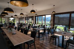 a restaurant with tables and chairs and large windows at Hotel Kühbergalp in Gunzesried