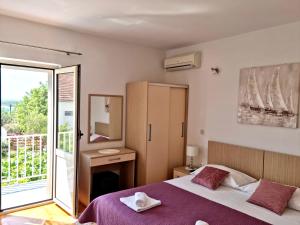 a bedroom with a large bed and a balcony at Apartments Nikola Stipišić in Hvar