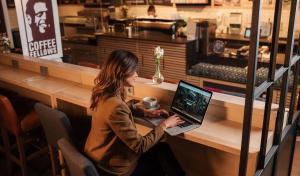 a woman sitting at a desk using a laptop at Coffee Fellows Hotel Dortmund in Dortmund