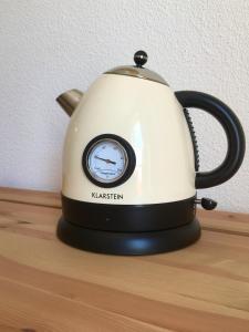 a black and white tea kettle sitting on a shelf at Appartement en face Hopital Nord in Saint-Priest-en-Jarez