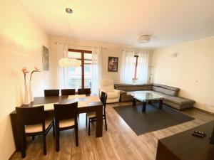 salon ze stołem i kanapą w obiekcie Brownie - Neptun Park by OneApartments w Gdańsku